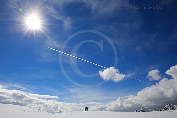 Sonne, Flugzeug, Wolken, Berge und das Gemeindewappen von Rohrmoos-Untertal
