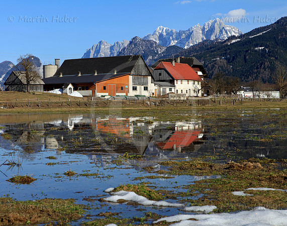 Bauernhof bei Admont spiegelt sich im Schmelzwasser